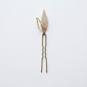 Pic à cheveux à intégrer dans des coiffures de mariage, réalisé à la main au fil de cuivre vernis à l'or. Il représente des feuilles légères et poétiques.