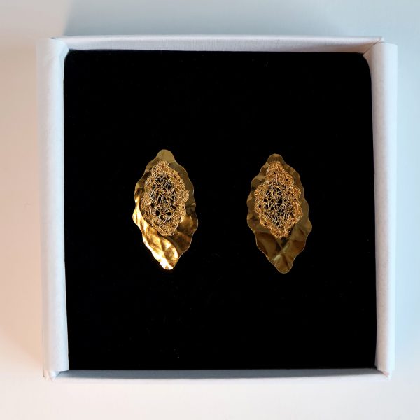 Boucles d'oreilles Lobos 1 dans leur boîte à bijou haut de gamme blanche et sa mousse noire, révélant l'éclat doré du métal.