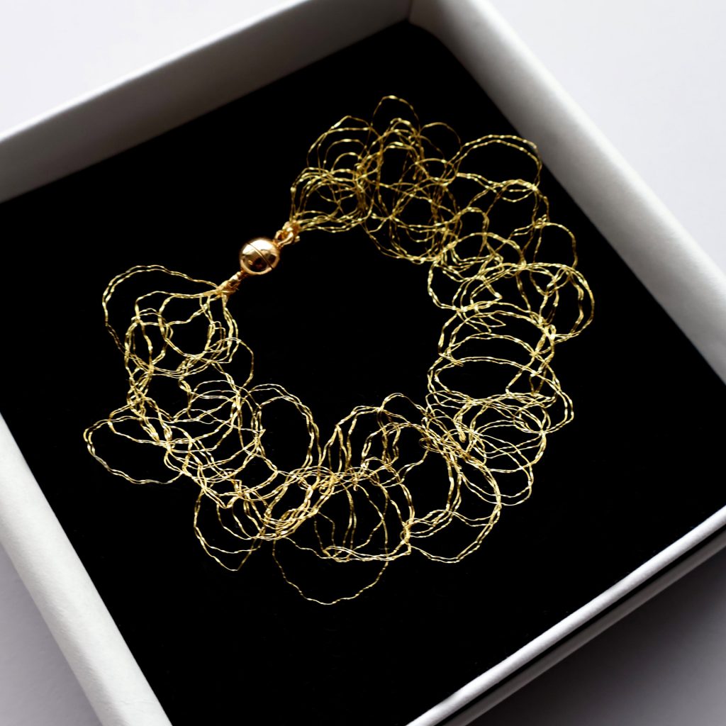Bracelet Lumi, bijou en maille métallique or jaune, signé Marie Archambaud, marque de bijoux brodés uniques. Le bracelet est bien protégé dans sa boîte.