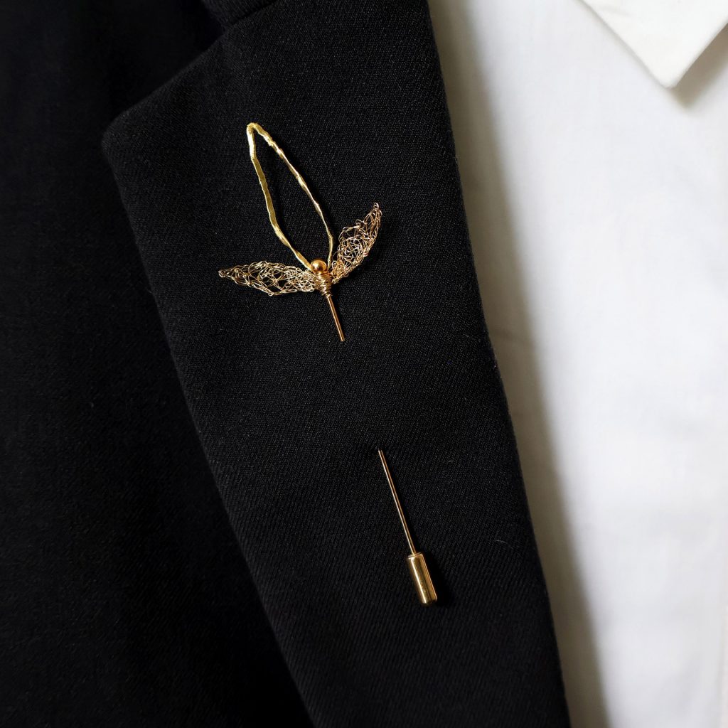 Broche boutonnière Elfo disposée sur veste de costume noir