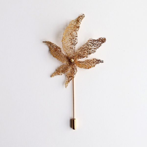 Eole est une boutonnière brodée de feuilles légères s'envolant au vent.