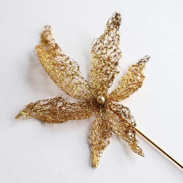 Détails de broderie au fil d'or avec perle au centre