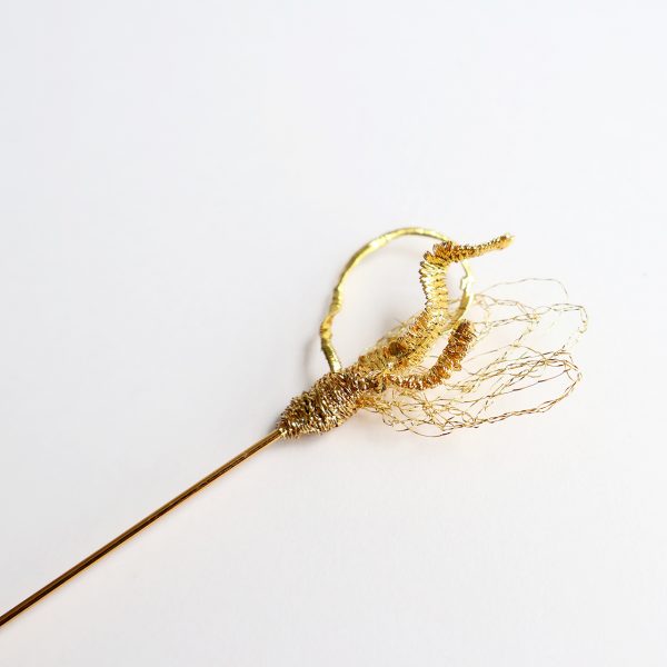 Détails de broderie au fil d'or sur fond blanc