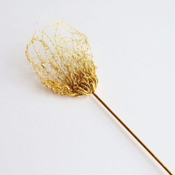 Détails de broderie au fil d'or sur fond blanc