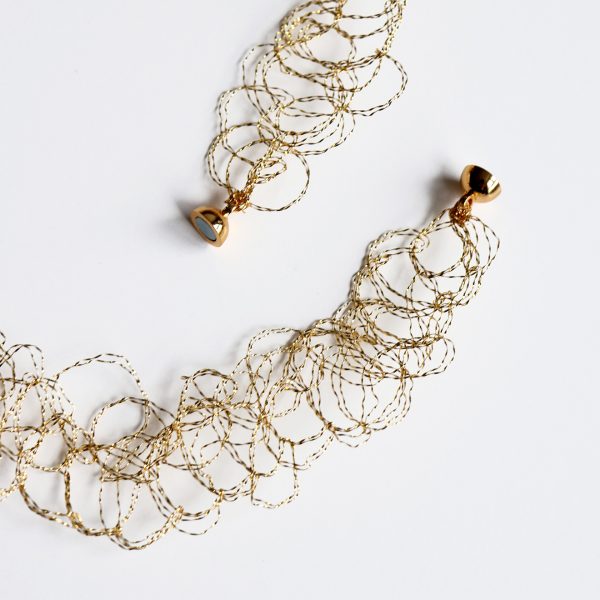 Détails de la maille métallique du collier Lumi et de son fermoir aimanté.