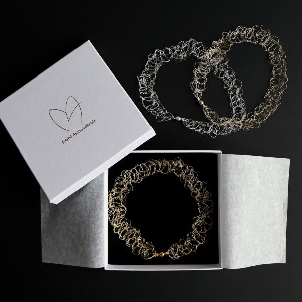 Trois colliers Lumio en or et argent sur fond noir avec écrin à bijou Marie Archambaud