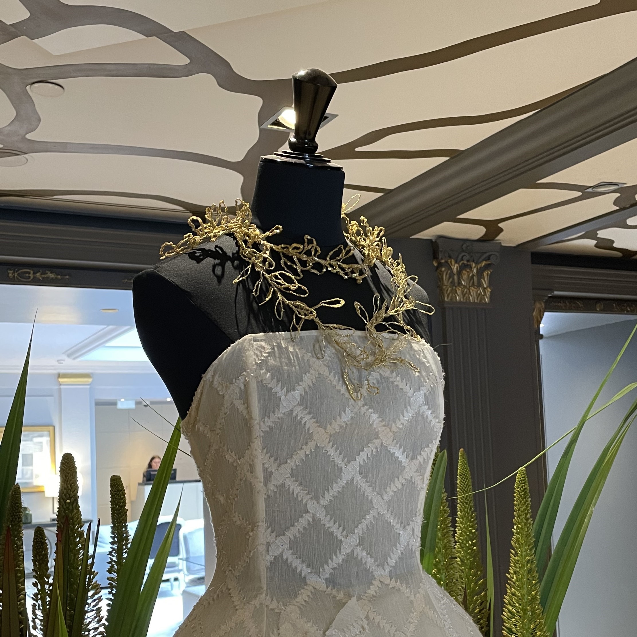 Foliusa, colliers brodés au fil d'or sublimant la robe blanche de la couturière Sophie Castagnetti lors de l'exposition Riviera à l'hôtel Parisien Sofitel Paris Faubourg en 2024
