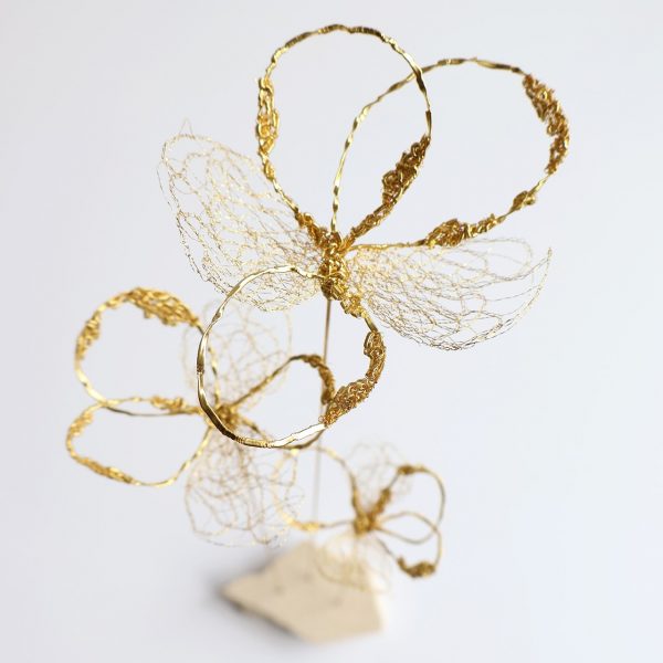Vue du haut de la sculpture Trifo, brodée de trois fleurs dorées