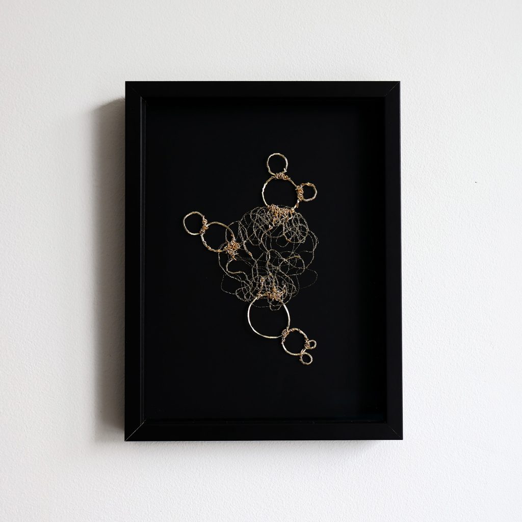 Broderie or Cytos 2 encadrée dans un cadre noir