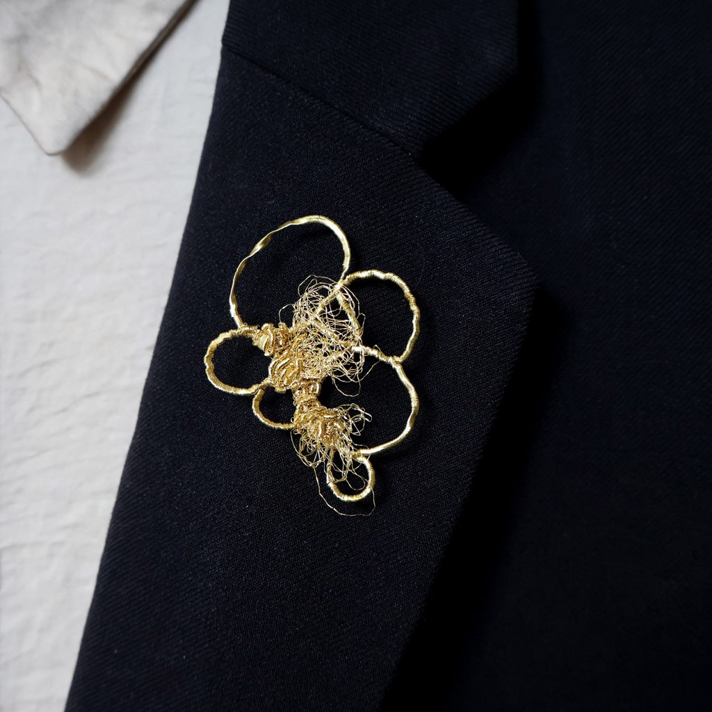 Costume orné de la broche brodée de fils d'or