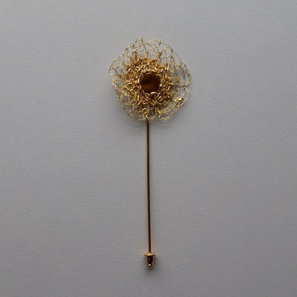 Broche boutonnière Stella sur fond gris, brodée à la main par la créatrice Marie Archambaud