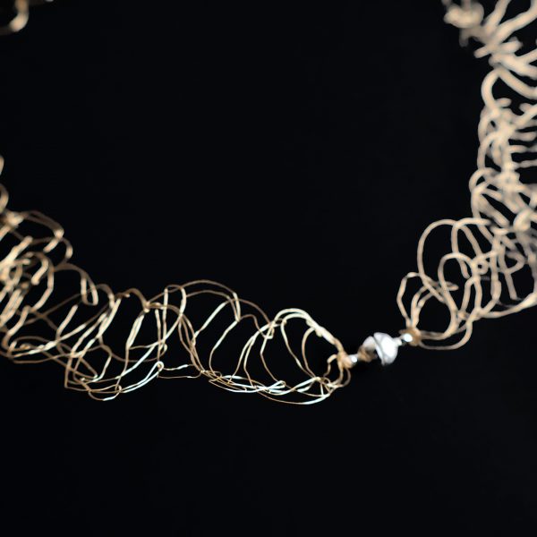 Détail de la maille métallique du collier Lumio or champagne